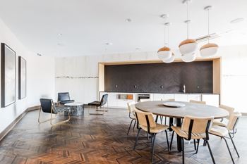 A dining room with a round table and chairs and a kitchen